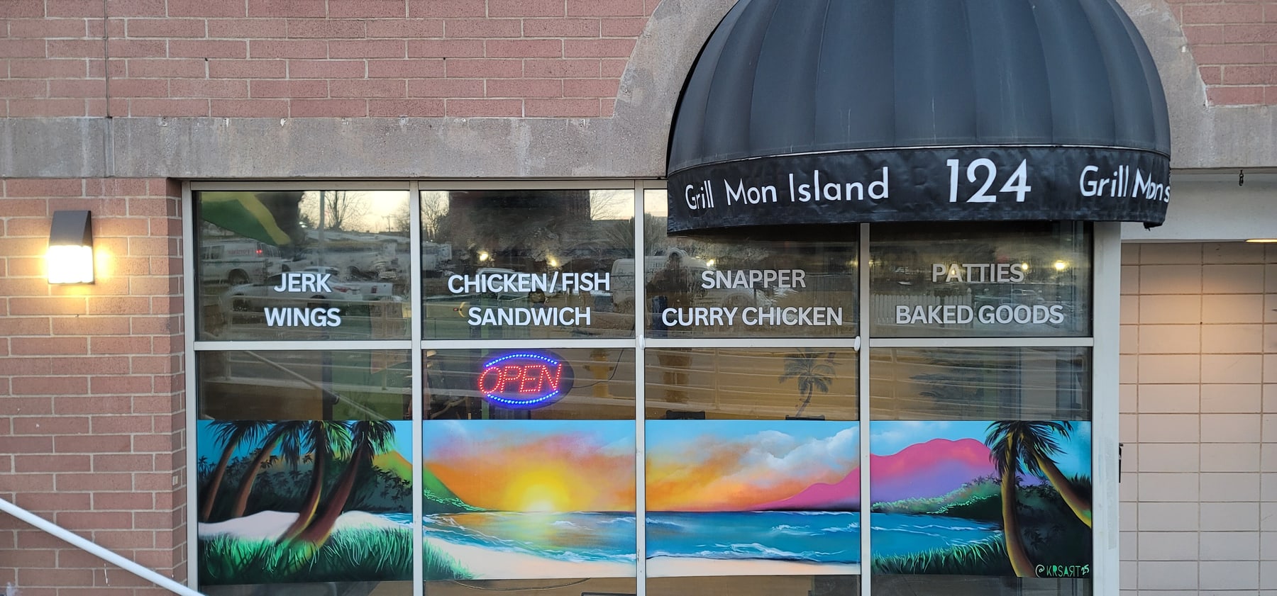 Grill Mon Island storefront window mural with a tropical sunset and shoreline