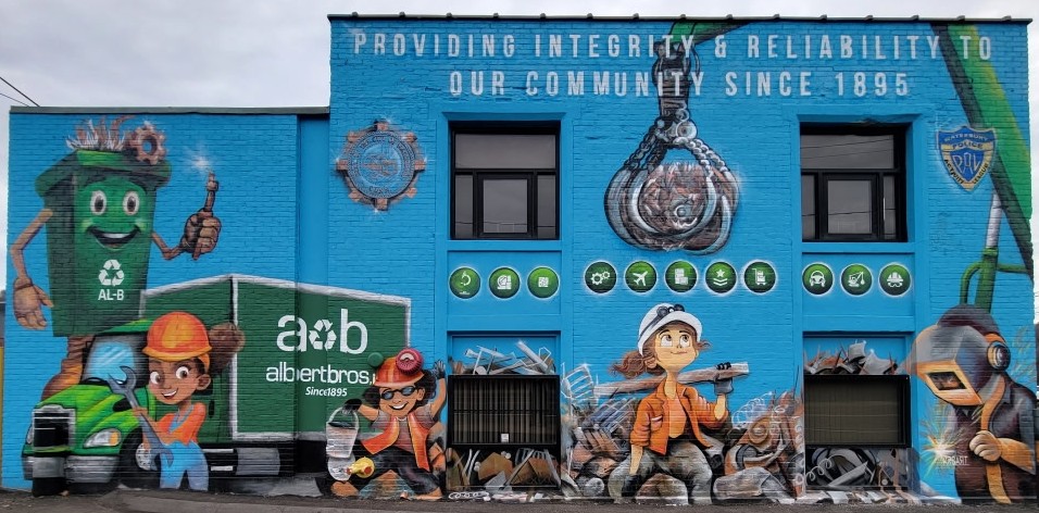 Albert Brothers scrap metal recycling company mural on a blue building facade with illustrated workers and brand graphics.